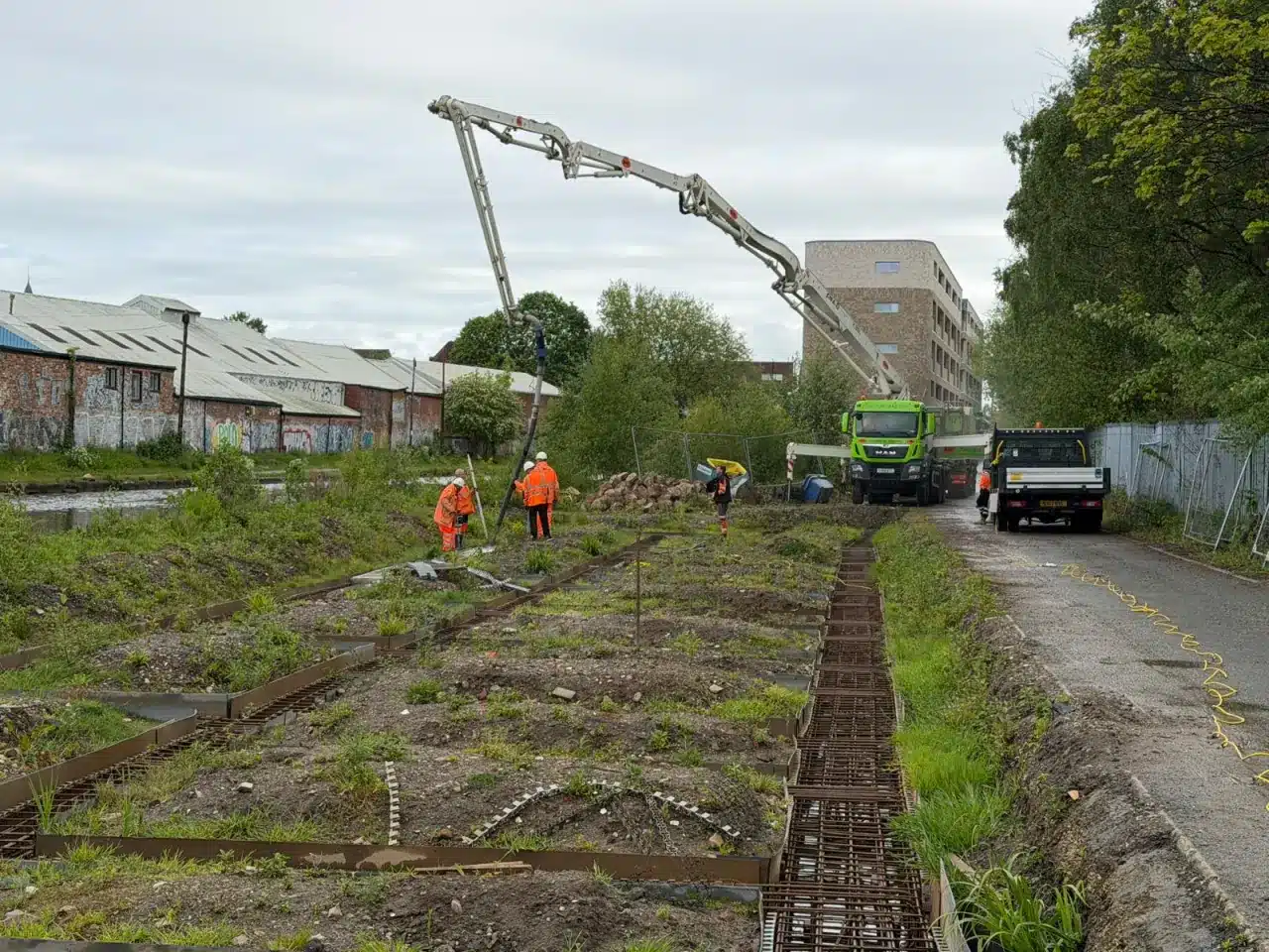 Boom pump pouring concrete for apartment foundations at Edgewater View, Stretford