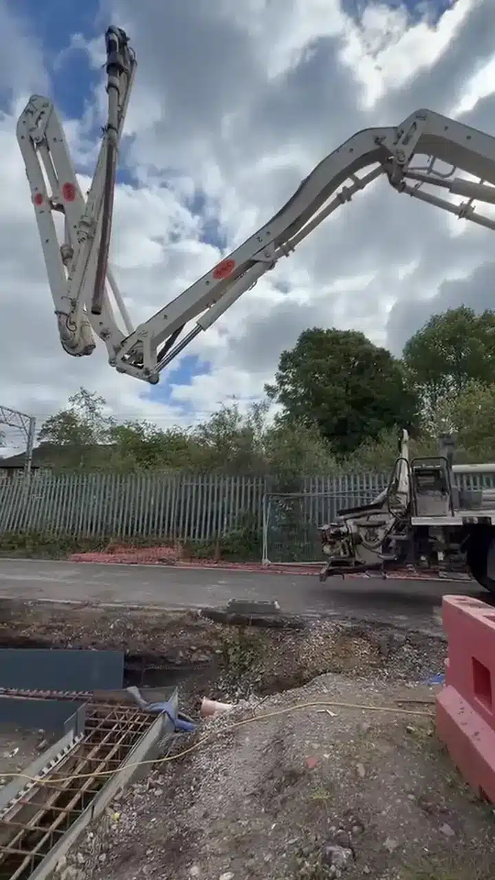 Boom pump arm placing concrete at the Edgewater View apartment site in Stretford