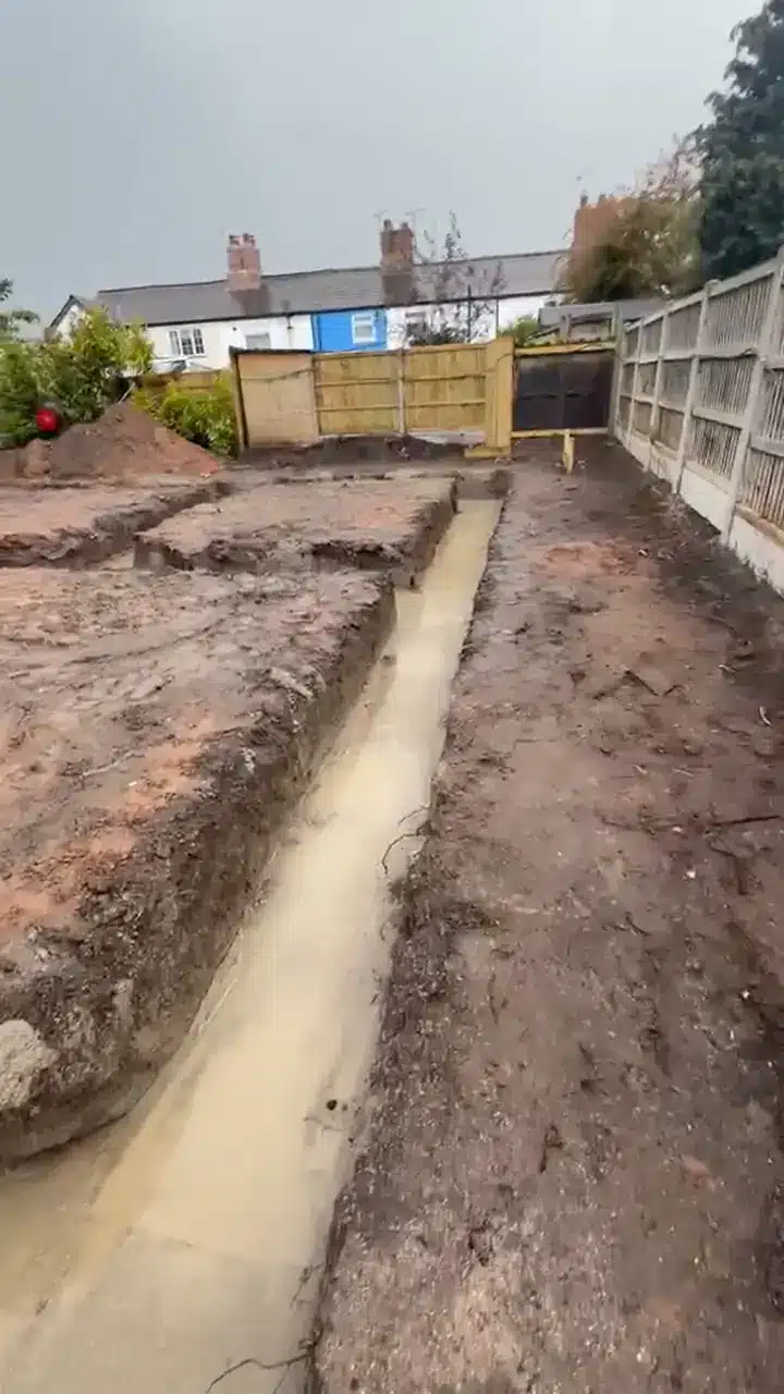 Line pump pouring concrete into new-build strip foundations in Northwich