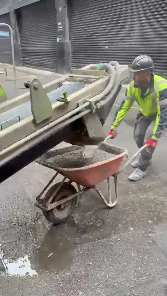 Worker barrowing concrete from the volumetric wagon at a new-build site