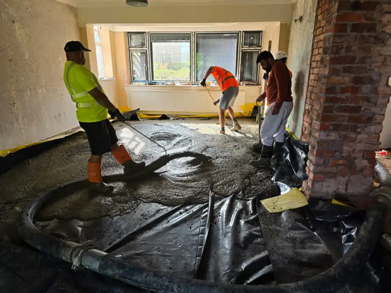 Barrow Mix team spreading freshly pumped concrete across a house floor in Bolton