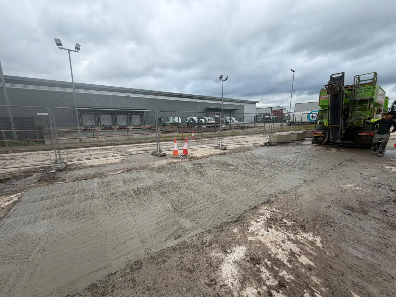 Freshly tamped concrete slab for the new weighbridge base in Salford with a Barrow Mix truck alongside