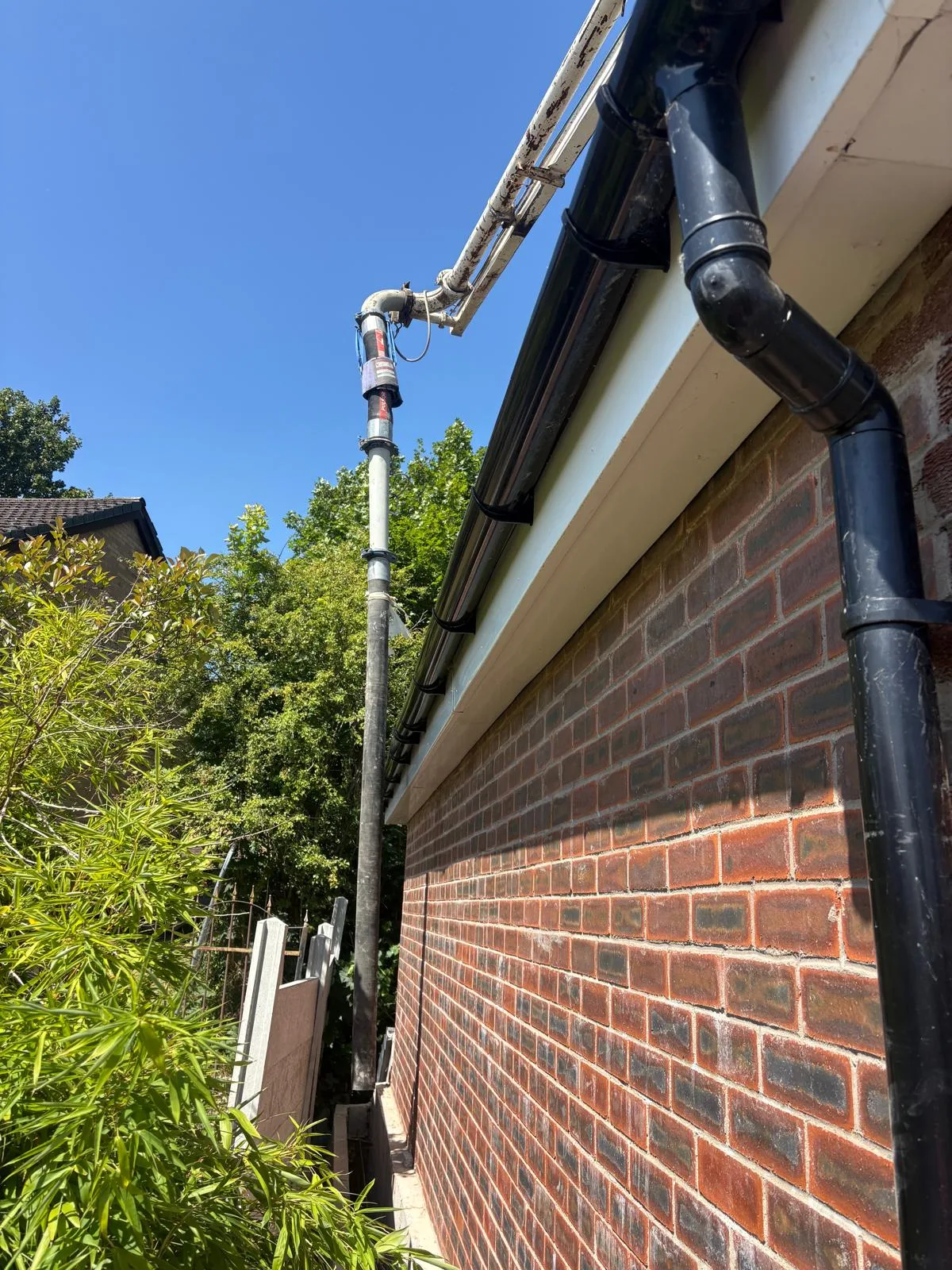Boom pump hose threaded down with an inch to spare against the side of the house