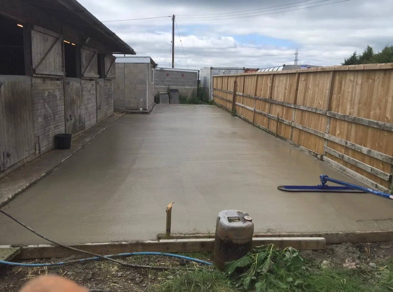The finished concrete dog run between the kennel block and fence