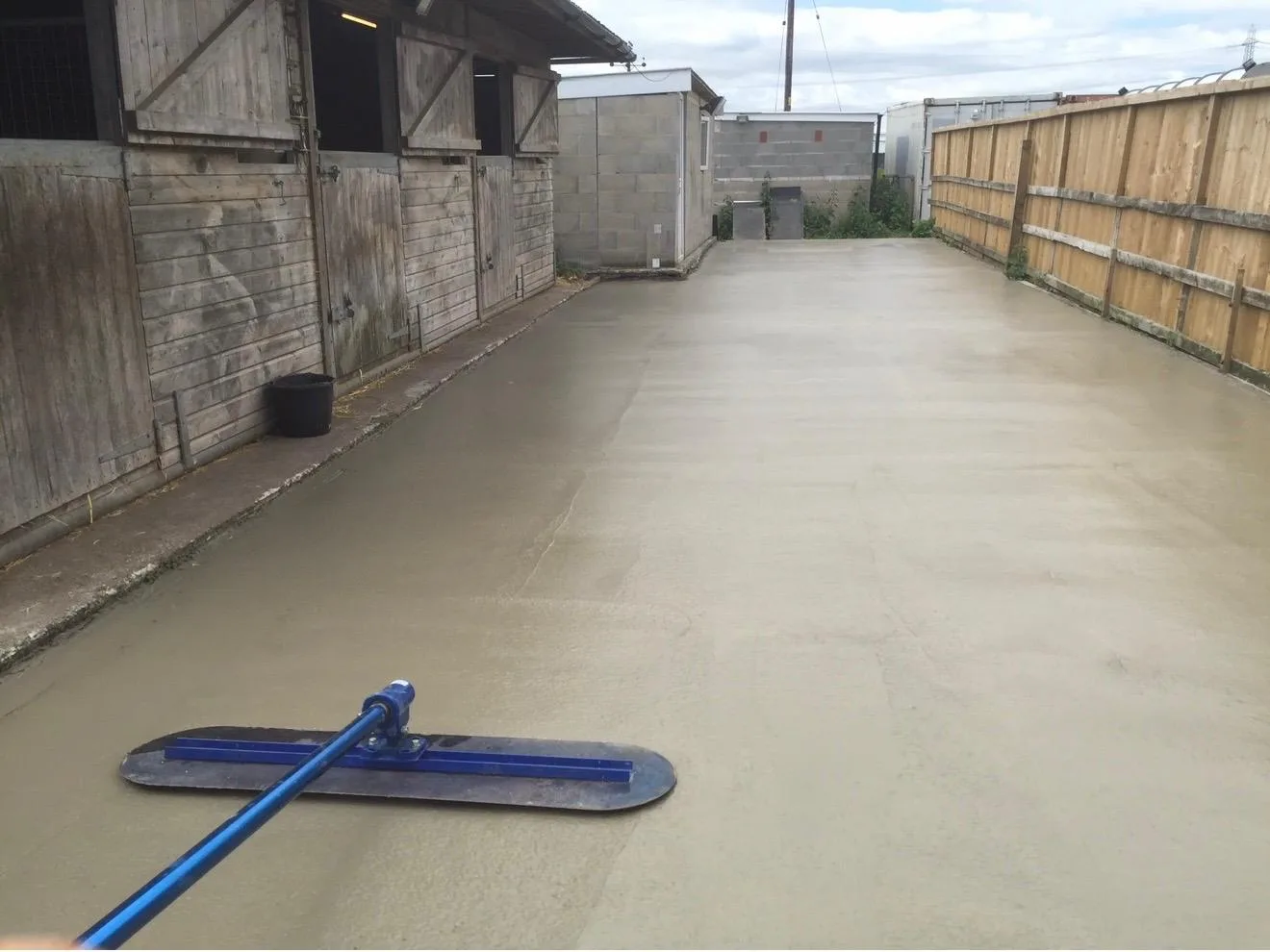 Bull-floating the fresh concrete dog run smooth at the Millington kennels