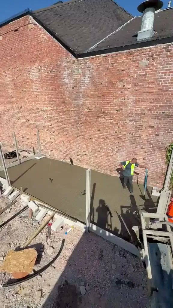 Barrow Mix concrete base poured and levelled against a brick boundary wall in Colwyn Bay