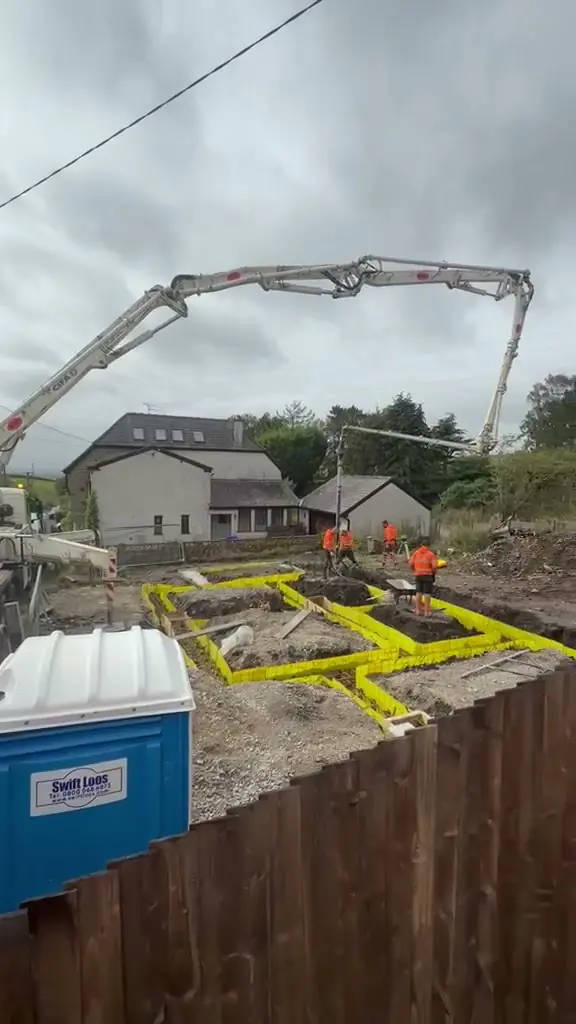 Boom pump placing concrete into the footings for two new builds in the Oldham area
