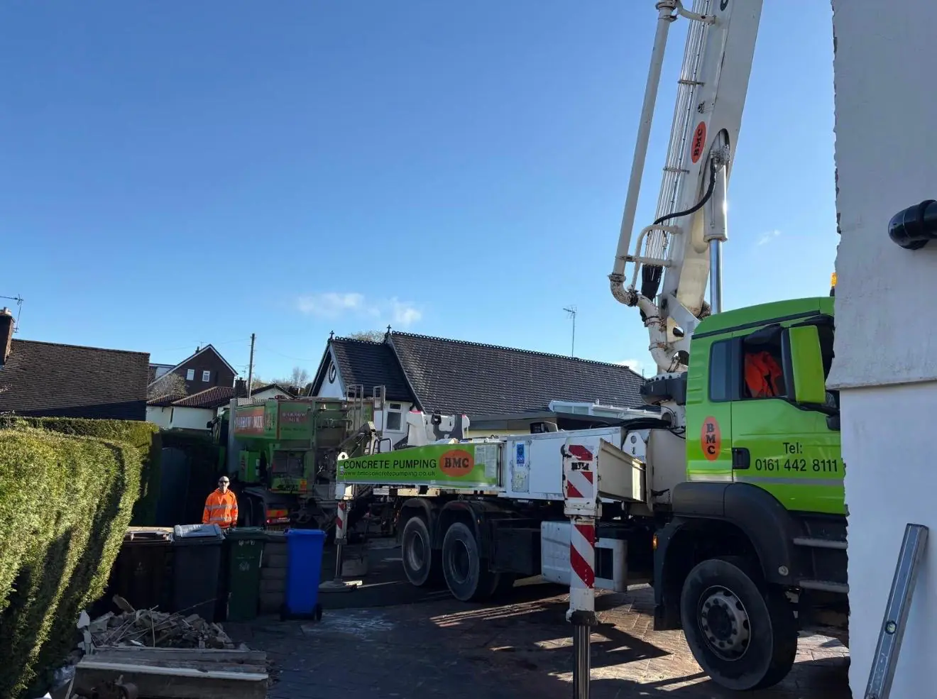 Concrete boom pump set up on the road outside a house in Rochdale