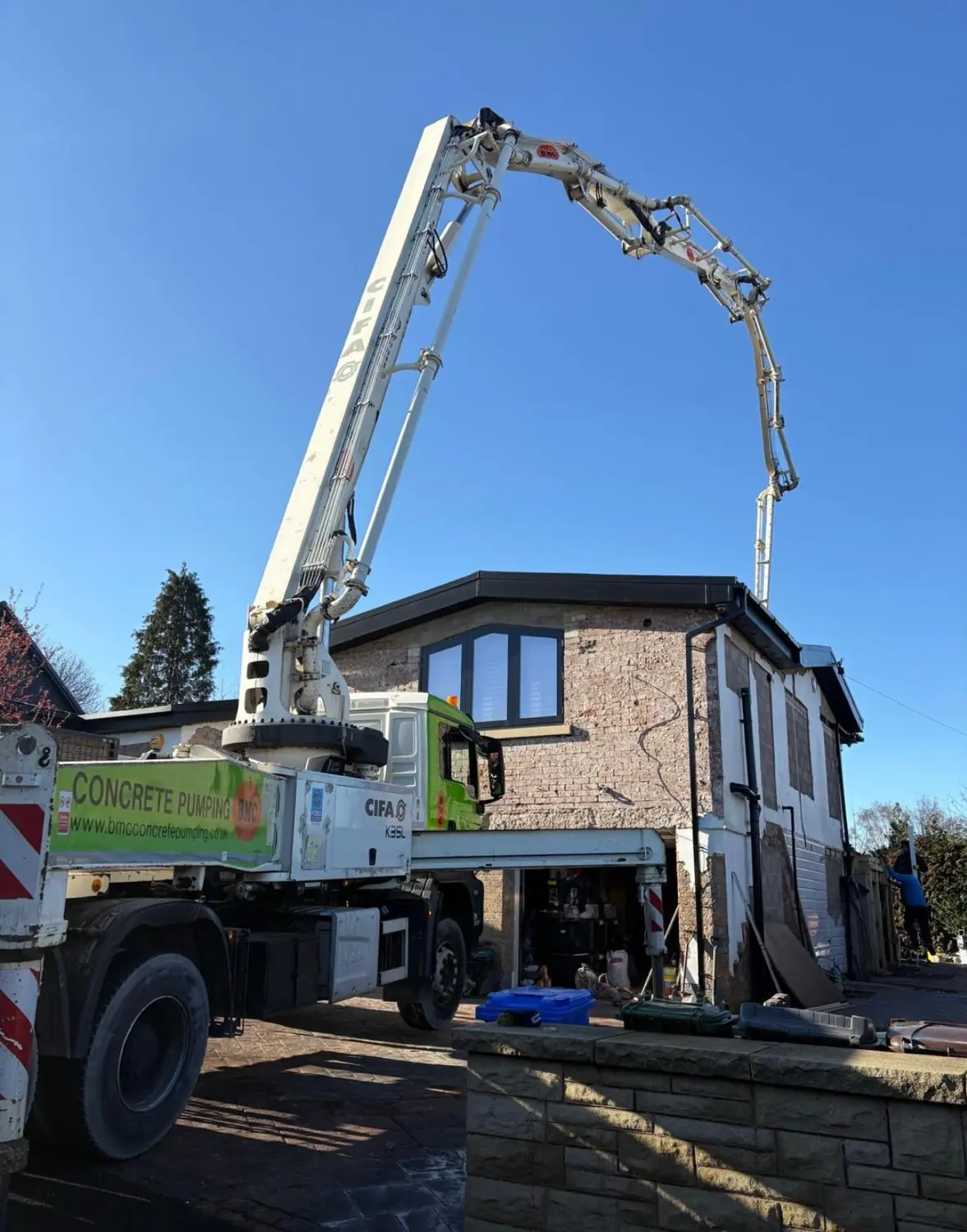 Boom pump reaching over a house in Rochdale to place concrete