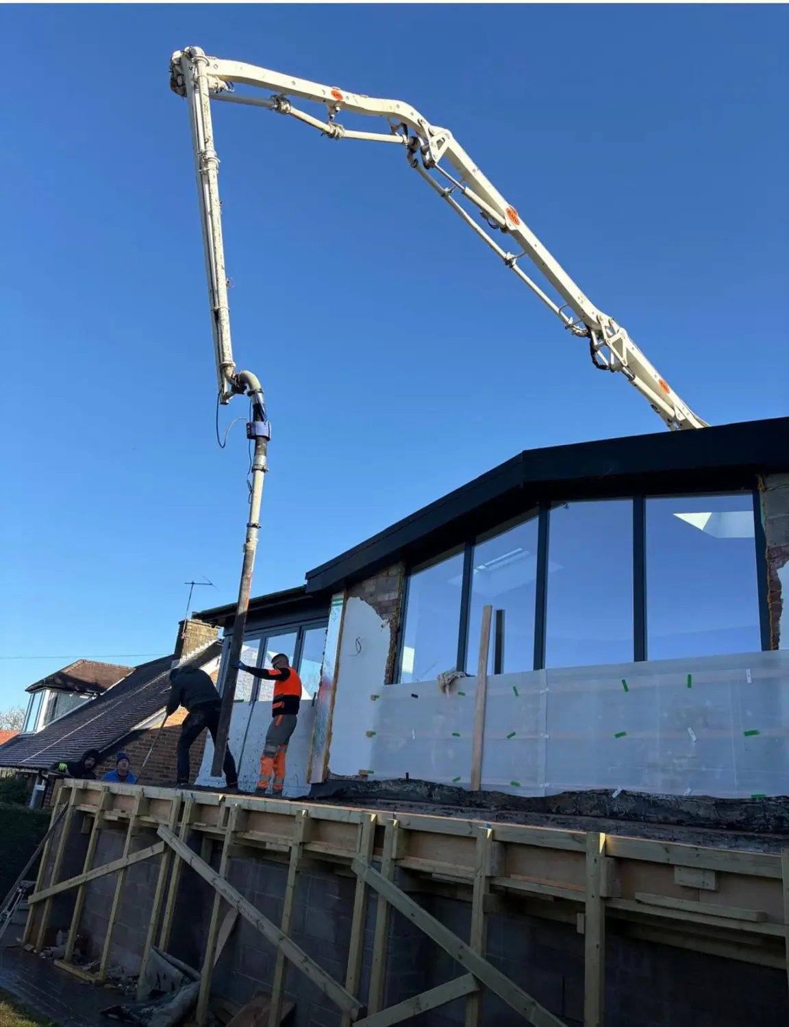 Boom pump placing concrete for a cavity wall and balcony slab in Rochdale