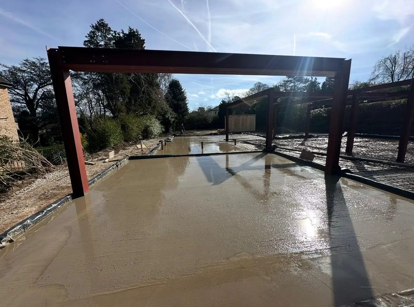Finished, floated concrete slab between the steel frames of the new build near Bowdon